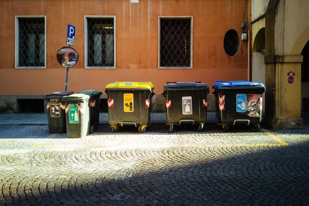Black and Blue Trash Bins Outside a Building